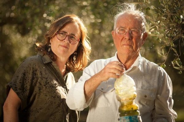 U padre con in mano una bottiglia d'olio e la figlia accanto
